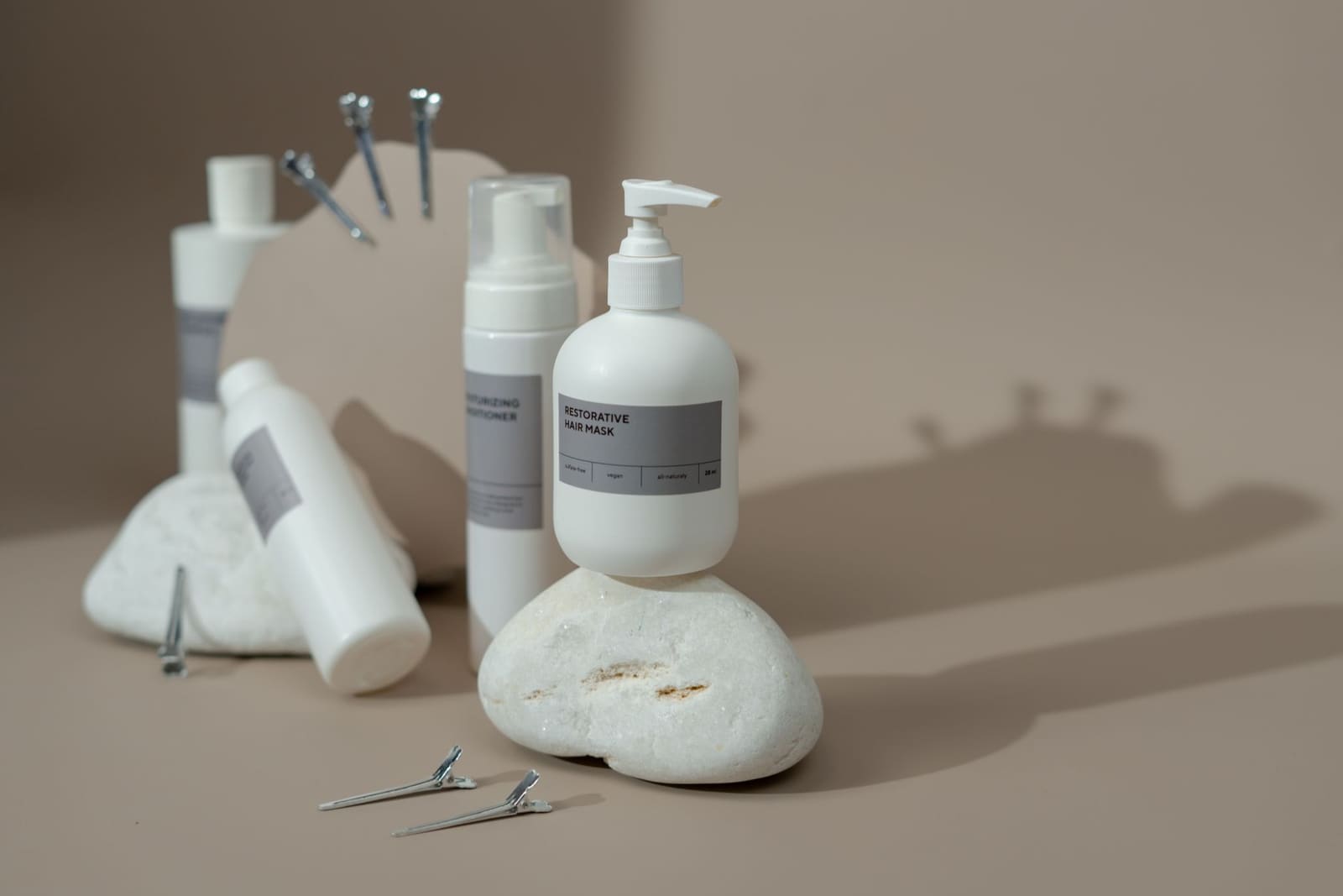 Frascos de shampoo, tônico e óleo da ESS Ecosmetics sobre fundo claro